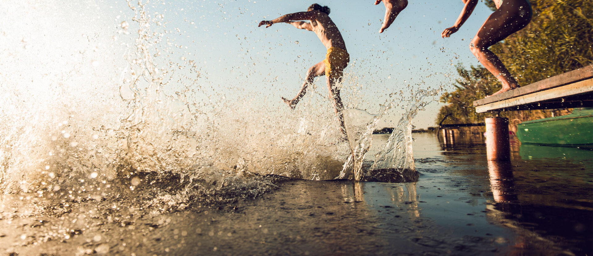 people jumping into a lake