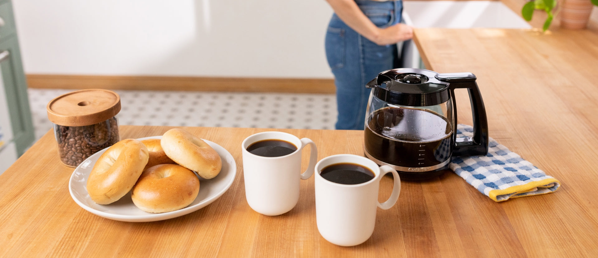 wood counter with coffee mugs and bagels