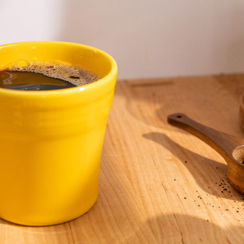 cup of smooth coffee in a bright yellow mug