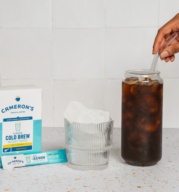 Cameron's Coffee cold brew instant sticks, stirring coffee in a glass with ice
